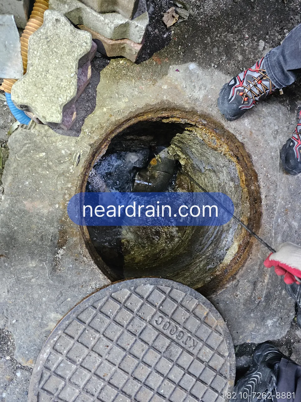 Manhole in front of a shop opened before opening hours for jetting