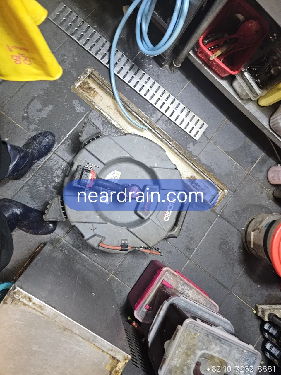 Camera reel beside a restaurant kitchen trench drain