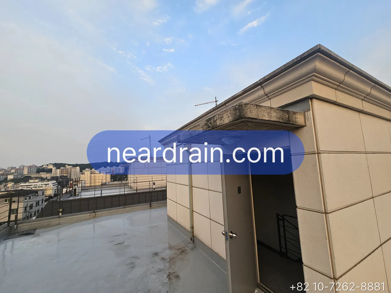 Rooftop terrace of a Seoul villa after rain, wet floor and the drain corner where water collects