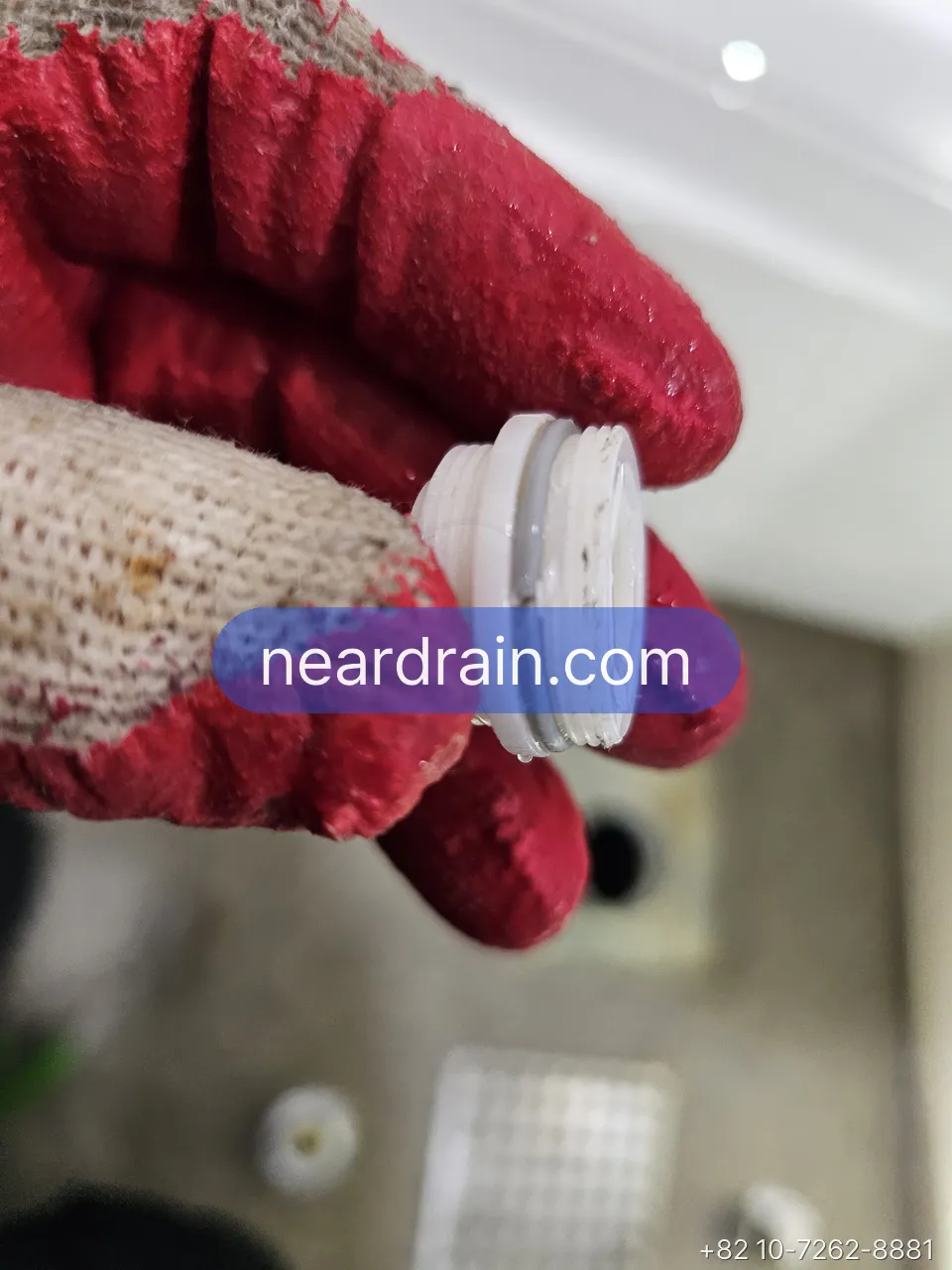 Eccentric wall adapter for a Korean shower mixer held in a gloved hand